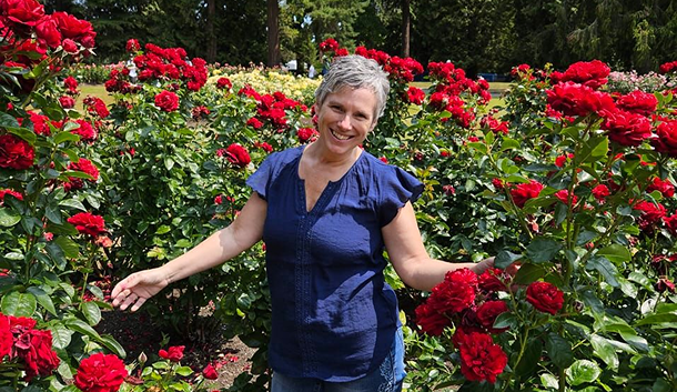 Amy Levesque, copywriter and ghostwriter - walking through a patch of red rose bushes.