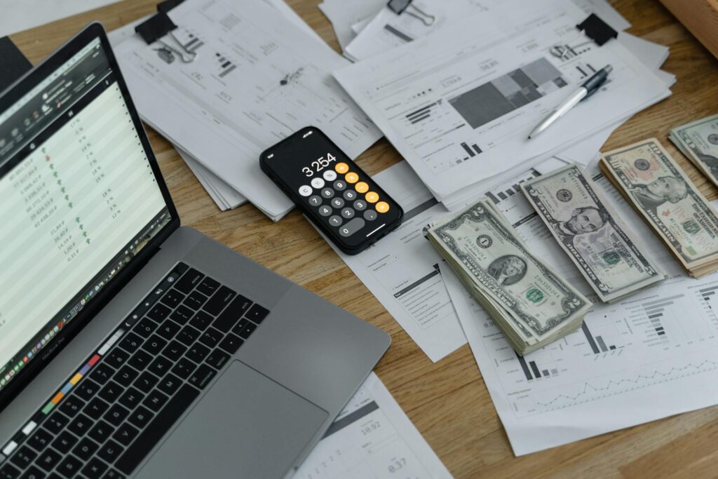 Financial Planning stock image, sorted bills in various denominations, and iphone calculator