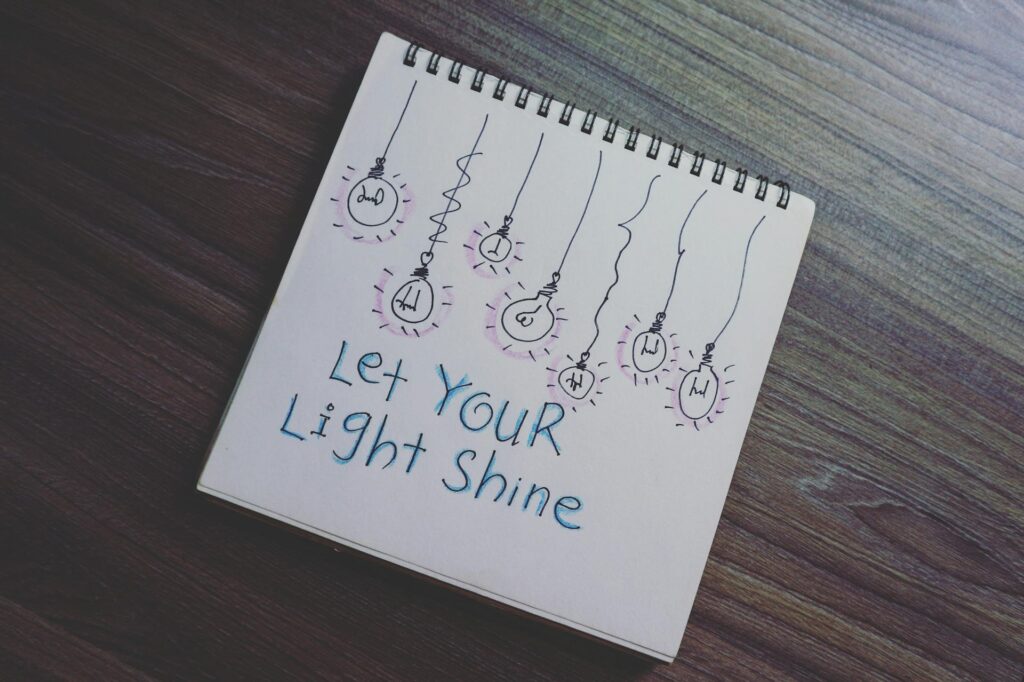 notepad with sketch that says "Let your light shine"